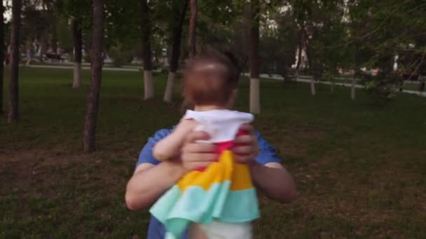 Papa cirkelen baby in haar armen en lachend lopen met hem in de stad. — Stockvideo