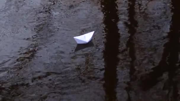 Suya yansıyan beyaz kağıt tekne geçerli ileriye taşır. — Stok video