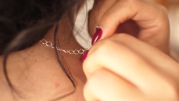Девушка одевает красивое ожерелье на шею — стоковое видео