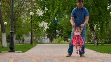 Baba küçük kızı bahar bahçe gitmek için öğretir. Küçük çocuk ile baba çalış, fırlatır bebek kadar mutlu ve gülüyor