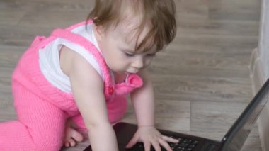 Çocuk ve bilgisayar. küçük kız bir dizüstü bilgisayar ile oynuyor