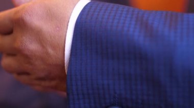 mavi ceketli adamı beyaz gömlek kol düzeltiyor