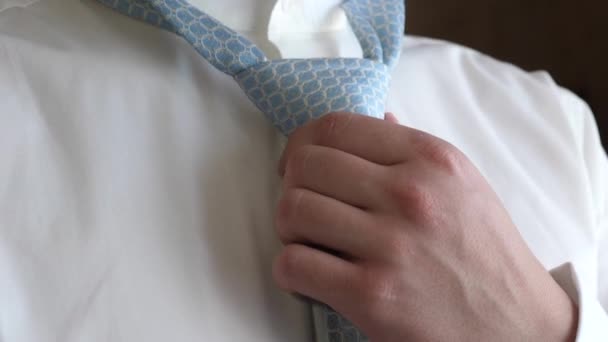 Man in white shirt ties up blue tie — Stock Video