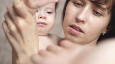 Anne kucağında bebek tutar. Bebek Baba gürlemesi ile elini daddys el üzerinde çalış.