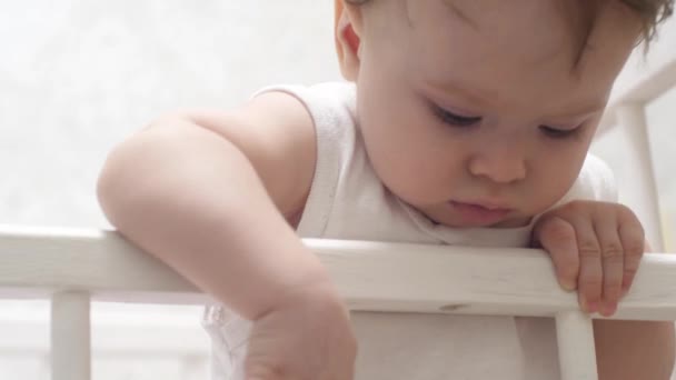 Criança joga emcama de bebê . — Vídeo de Stock