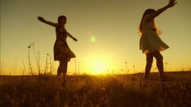 Golden sunset ışınları altında Uçuş uzun saçlı kızlar gençler whirl. Ağır çekim.