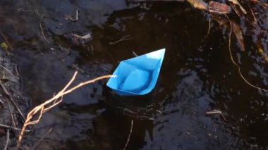 şeffaf nehir, bir dere ile akan küçük mavi kağıt tekne yansıyan bu ağaçlar. yakın çekim