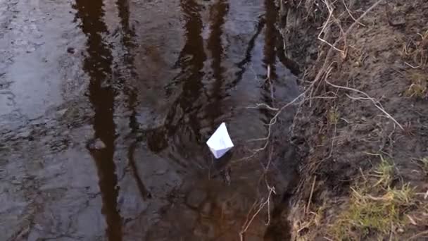 Piccola barca di carta bianca galleggiante sul fiume limpido nel parco autunnale — Video Stock