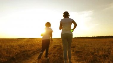 Genç kızlar günbatımında koşu ve müzik pratik vardır. kırsal kesimde spor oynarken müzik kulaklık genç kız.