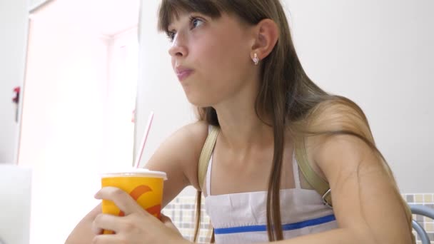 Chica en la cafetería y beber cóctel a través de una paja — Vídeo de stock
