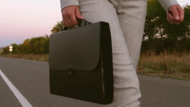 Woman in business suit with a black briefcase in her hand goes to work. closeup — Stock Video