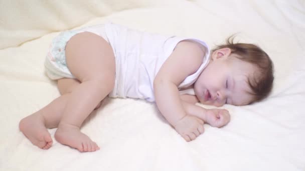 Small baby sleeps in his crib on white blanket. — Stock Video