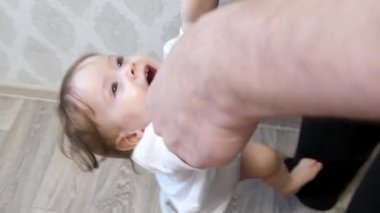 Küçük bebek, öğrenir ayakta durmak üstünde onun legs, babasıyla birlikte ellerini tutun.