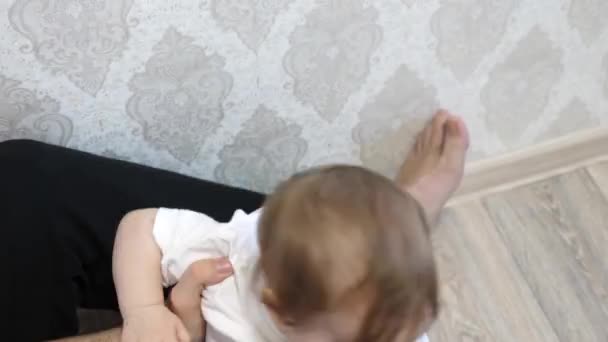 Papa speelt met de baby, gooit het naar de top, en het kind lacht, in de kinderkamer. — Stockvideo