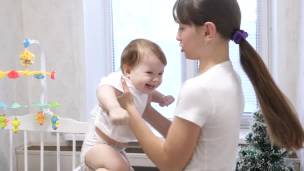 Uma jovem mãe brinca com uma criança na sala das crianças e elas riem . — Vídeo de Stock