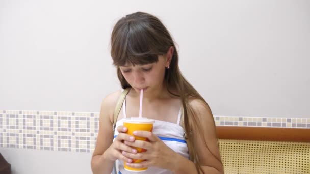 Dívka v kavárně je pít lahodný koktejl a s úsměvem. — Stock video