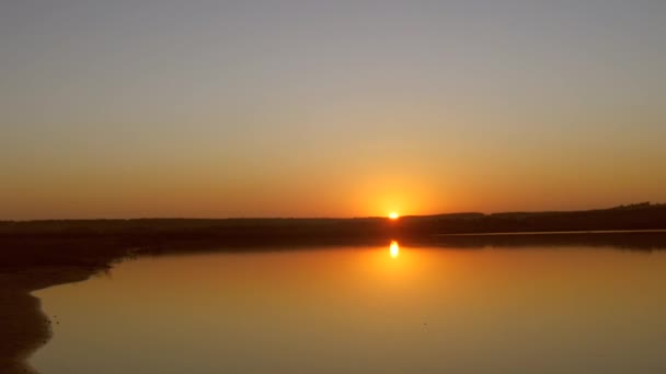 Красивий захід сонця над осіннім озером, сонце відбивається у воді — стокове відео
