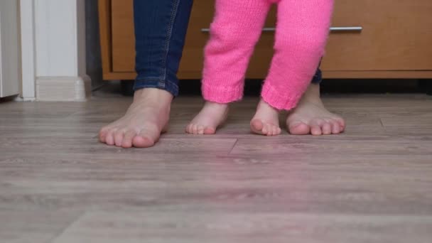 Nohy dítěte a matky jít naboso na podlaze — Stock video
