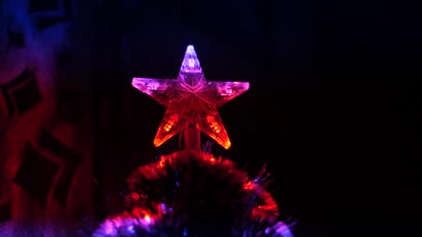 Estrella de Navidad brilla con luces de colores en el árbol de Navidad en la habitación de los niños — Vídeo de stock