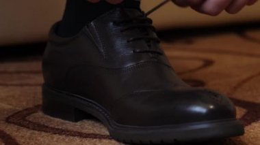 mens eller üzerinde siyah ayakkabılar, ayakkabı bağcığı bağlama yakın çekim