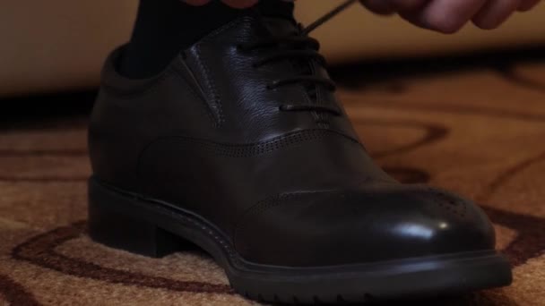 Mens hands tying shoelaces on black shoes, close-up — Stock Video