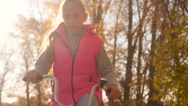 Ellerini kızın eğri Bisiklet gidon tutun. Bisiklete binmek ve sonbahar parkta gülümseyen kız. yakın çekim — Stok video