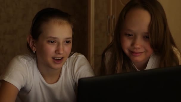 Teen girls do homework using laptop and laugh. Games through application online — Stock Video