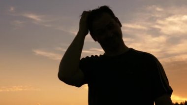 adam silüeti başını gökyüzüne karşı tırmalamak