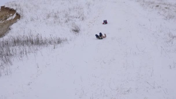 Teenagermädchen reiten mit weißen schneebedeckten Bergen und lachen. Weihnachtsferien. Winterspiele. Zeitlupe — Stockvideo