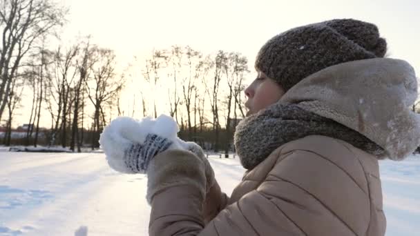 Menina bonita soprando na neve fria branca. Hora de Inverno. Jogos de neve — Vídeo de Stock