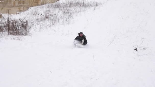 幸せな男は、白い雪に覆われた山々 と笑いに乗る。クリスマス休暇。冬のゲーム。スローモーション — ストック動画