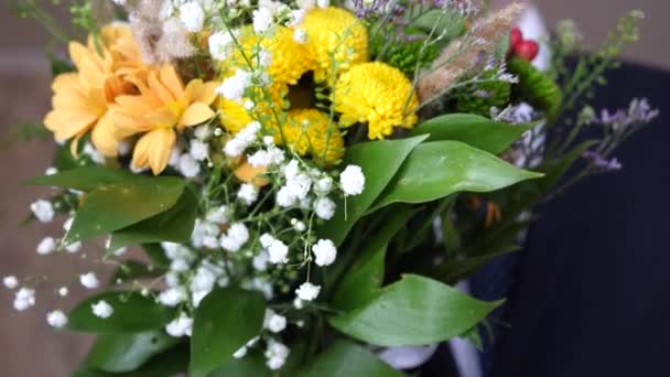 穿着西装的人拿着美丽的花束与格伯拉斯和罗万。弗洛里斯 — 图库视频影像