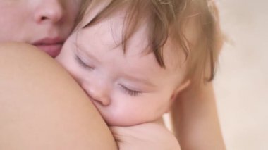 Anne yatan küçük sevgili bebek kollarında sallıyor. Annelik sevinci. Anne ve çocuk. Doğum izni. Yakın çekim