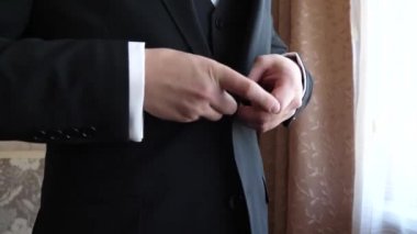 eller erkek siyah bir üç parçalı takım elbise üzerinde düğme tutturmak. yakın çekim