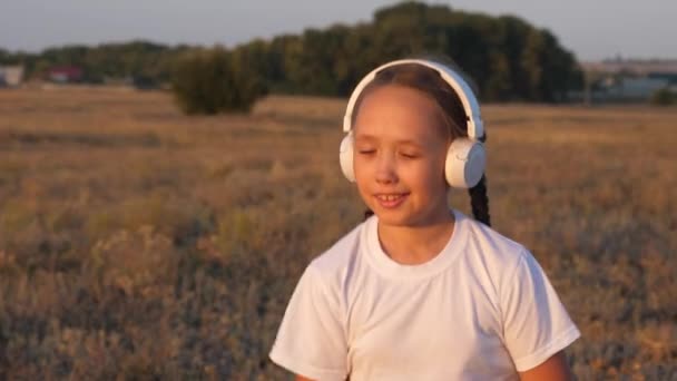 Κορίτσι πηγαίνει για σπορ και ακούει μουσική στα ακουστικά. Αργή κίνηση — Αρχείο Βίντεο