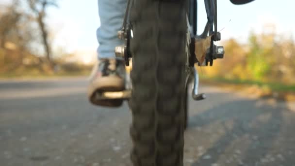 Jambes de fille poussant pédales de vélo. roue avec roulement, gros plan. balades à vélo sur route asphaltée . — Video