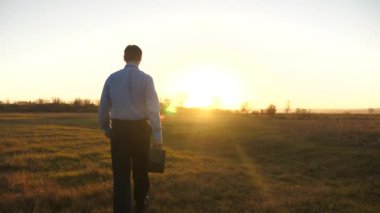 Evrak çantası ile iş adamı iş günü sonra güzel gün batımı devam ediyor