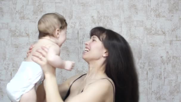 Gelukkig weinig baby soars in lucht in handen van de moeder en lacht — Stockvideo