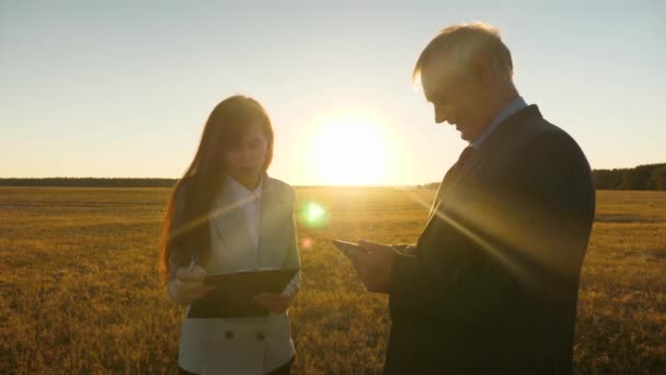 Homme d'affaires avec mallette et femme d'affaires avec tablette négocient au coucher du soleil et rient. Réunion d'affaires avec le partenaire de travail — Video