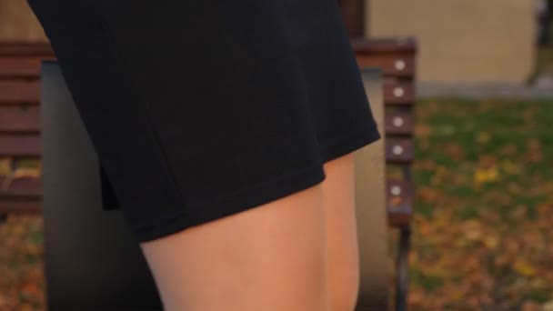 Geschäftsfrau mit schönen Beinen in Rock und Strumpfhose läuft mit schwarzer Aktentasche in der Hand durch den Herbstpark. schöne weibliche Beine. Nahaufnahme — Stockvideo