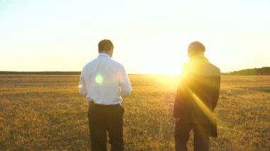 Evrak Çantası'nı el ile ciddi elbiseli yaşlı bir işadamı parlak batan güneşin akşamları şirket çalışan için çalışma planı verir