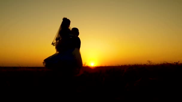 Happy bride and groom circled on background of a romantic red sunset. Honeymoon. — Stock Video