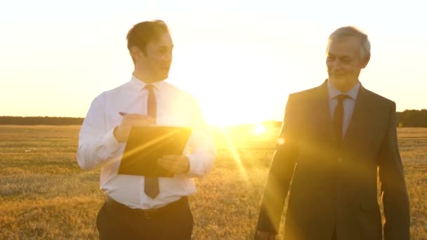 Reunión de negocios con un socio de trabajo en el parque al atardecer. Empresarios discuten plan de trabajo en equipo con sol brillante . — Vídeo de stock