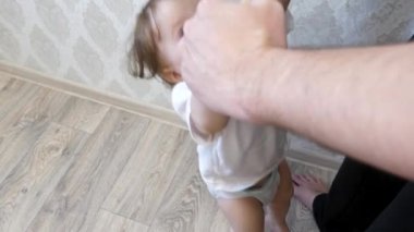 Küçük bir çocuk babası elleriyle tutar. Atlar çocuklar ve güler, baba ile çalış.