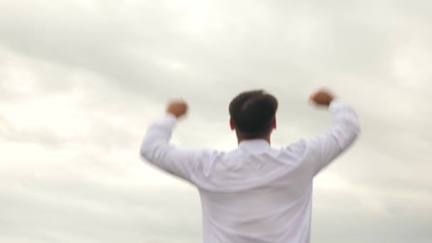 Zakenman in wit overhemd tegen de achtergrond van de donkere wolken — Stockvideo