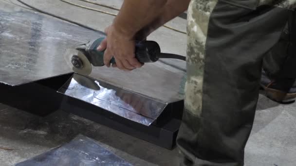 Arbeiter schneidet glänzendes Blech, Schleifer elektrisch. Schlosser arbeitet in einer Fabrik. Nahaufnahme — Stockvideo