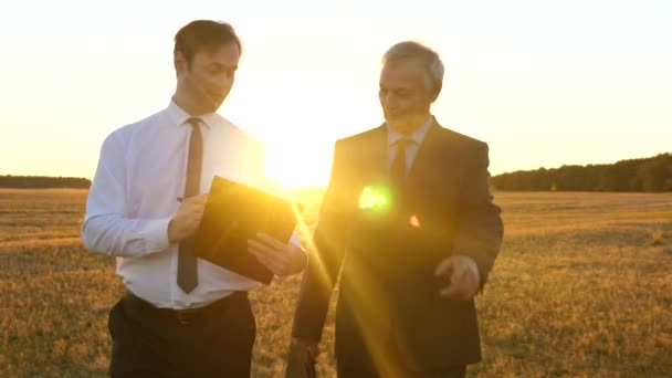 Réunion d'affaires avec le partenaire de travail dans le parc au coucher du soleil. Les hommes d'affaires discutent du plan de travail d'équipe sous un soleil radieux . — Video