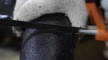 Tesisatçı beyaz koruyucu eldiven testere siyah tüp demir testeresi ile. yakın çekim