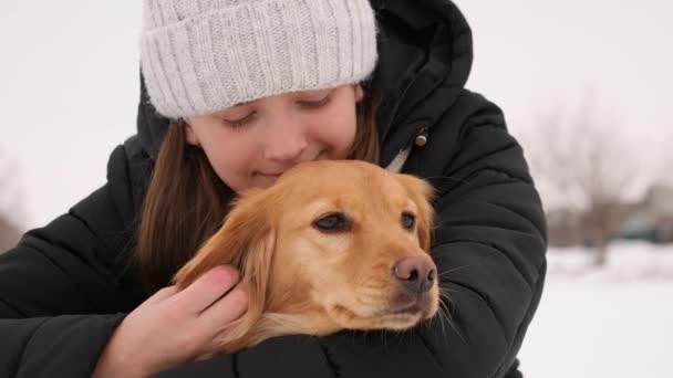 Gadis berjalan di musim dingin dengan anjing di jalan. nyonya membelai anjing di belakang telinga dan tersenyum . — Stok Video