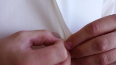 eller bir adam beyaz bir gömlek düğmeleri kadar düğmelerini. adam beyaz gömlek, yakın çekim